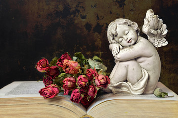 Condolence card. Angel, roses and old book on grunge background