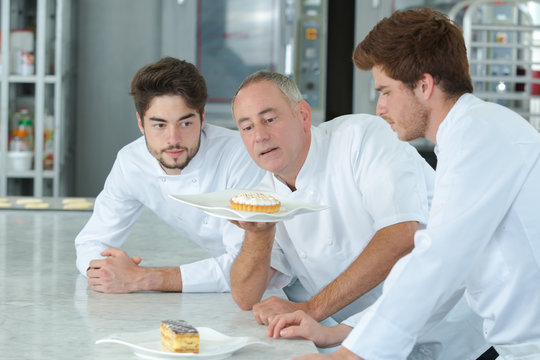 Chef and interns looking at cakes
