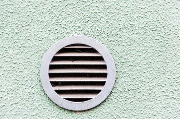 circular plastic air vent in white wall ventilation grille