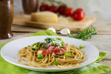 whole wheat spaghetti pasta with fresh tomato sauce, fried spring onions and parmesan cheese