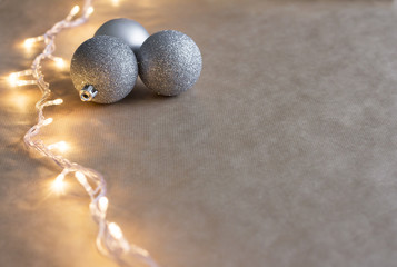 Warm gold garland lights and Christmas balls on paper. Selective focus. New year background.