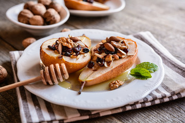 Sweet baked pears with honey, walnuts, almond cranberries and cinnamon