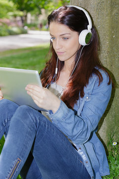young beautiful smiling woman with tablet outdoors