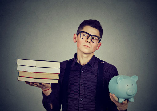 Student loan concept. Man with pile of books piggy bank full of debt