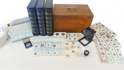 Coins of different countries of the world on white table with folders and supplies background -...