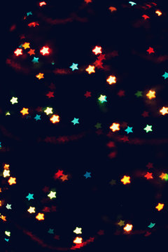 Christmas, New Year background with beautiful stars bokeh of colorful garland lights