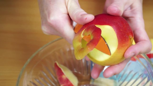 Woman housewife in kitchen at home peeling apple fruit for salad or juicing. Healthy eating, cooking, raw food, dieting and people concept. 4K ProRes HQ codec