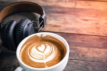 Tuinposter latte coffee cup and headphone on table © deaw59