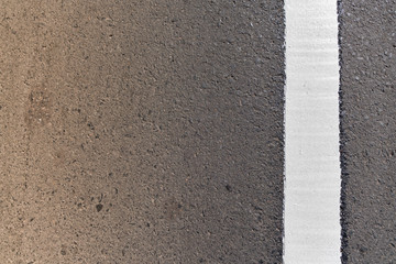 new white vertical line with warm light on the road texture.
Tarmac texture and copy space