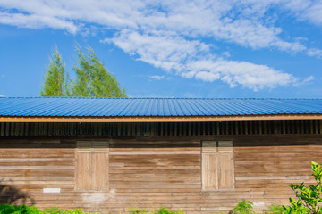The old wooden building roofed with blue sheet metal roofs and sky background.