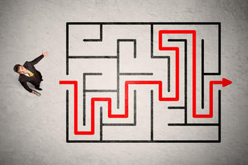 Lost businessman found the way in maze with red arrow