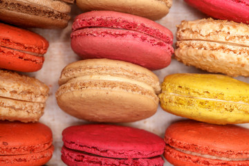 Many traditional french colorful macarons in a box, close-up
