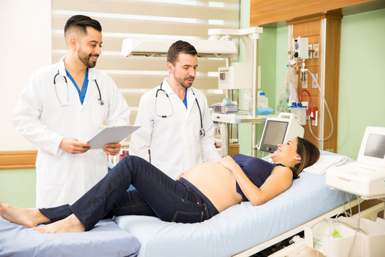 Two doctors checking on a pregnant woman