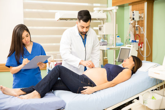 Doctor and nurse examining pregnant woman