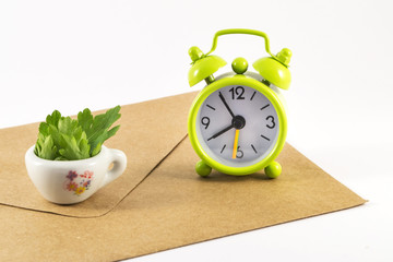 Alarm clock and envelope on white background