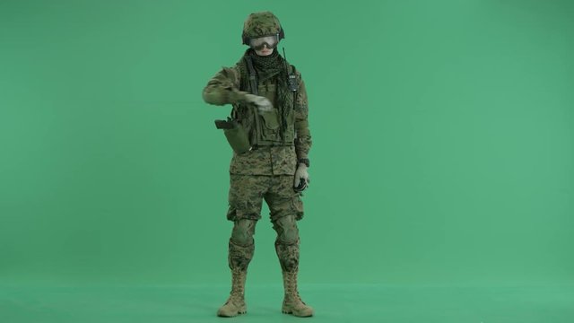 Soldier holding invisible bomb at green screen