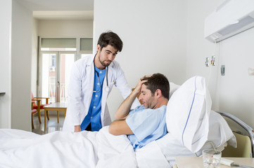 Fototapeta premium doctor consulting patient lying on hospital bed talking worried giving bad news about the diagnose