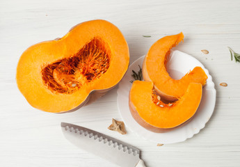 raw chopped pumpkin on white wooden background