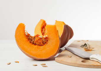 raw chopped pumpkin on white wooden background