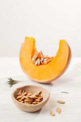 cut pumpkins and seeds on wooden background