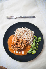 Barley groats with stewed meat and kale served on a plate