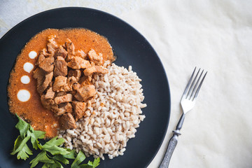 Barley groats with stewed meat and kale served on a plate