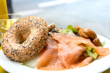 Bagel with fresh Salmon and fresh lettuce on table