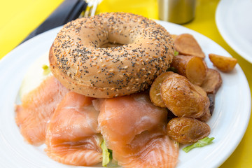 Bagel with fresh Salmon and fresh lettuce on table
