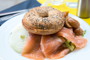 Bagel with fresh Salmon and fresh lettuce on table