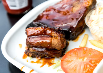 Grilled meat ribs on the plate with hot sauce