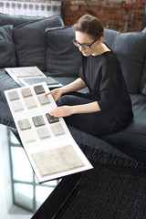 Architekt wnętrz. Kobieta wybiera wykładziną dywanową do salonu - obrazy, fototapety, plakaty