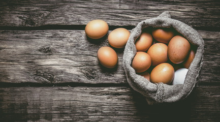 Eggs with an old bag. On wooden table.