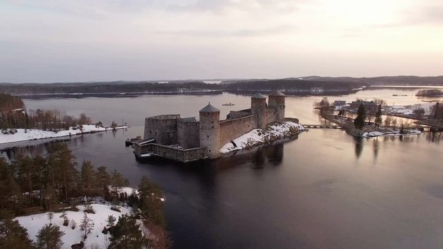 Aerial shot of a medieval castle in the middle of a lake landscape