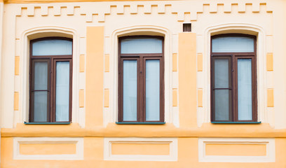 Three historic brown window on the yellow wall