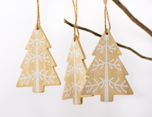 Christmas and New Year decoration, wood fir trees with white ornament hanging on a dry tree branch on white background, selective focus