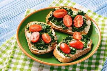 Toasts with spinach, cream cheese and tomatoes.