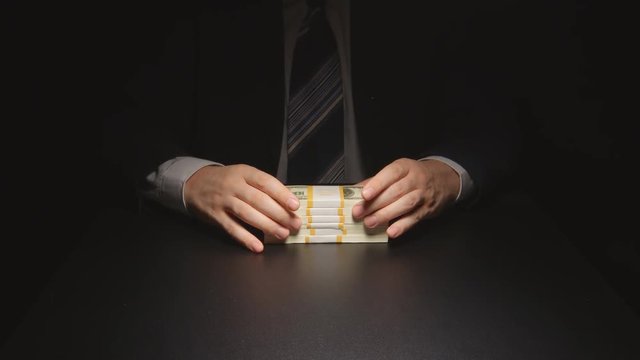 Bribe: Businessman waits, touches a money bundle and gives it