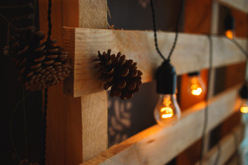 Christmas tree pine cones and lamps on wooden background