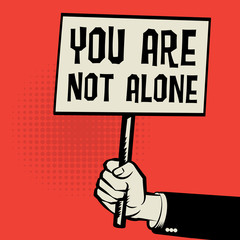 Poster in hand, business concept with text You Are Not Alone