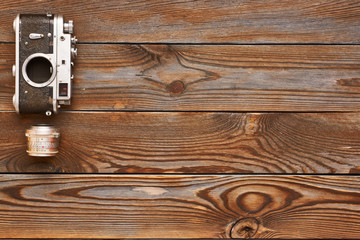 Fototapeta premium Vintage old camera and lens on wooden background