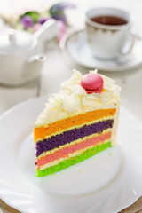 Fancy cake with macaroon on top and cup of tea