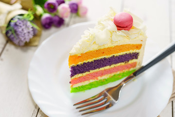 Fancy cake with macaroon on top and cup of tea