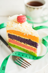 Fancy cake with measure tape and cup of tea