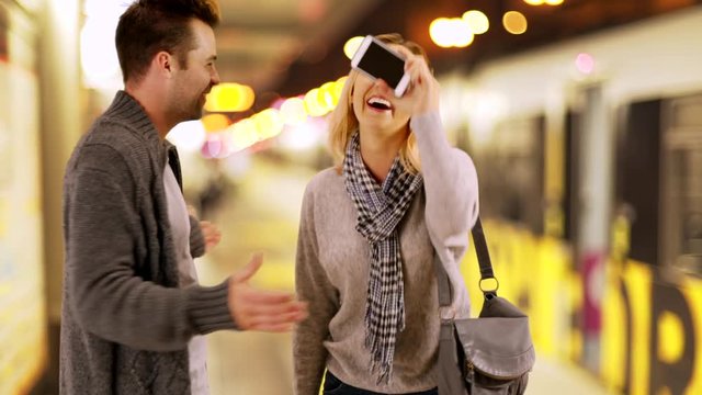 Millennials playing games with their smartphone while waiting for their train