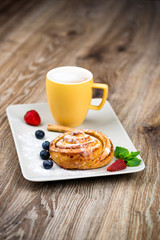 Cup of coffee and pastry on wooden background