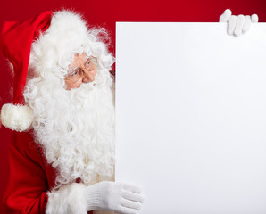 Santa Claus pointing in blank advertisement banner isolated on r