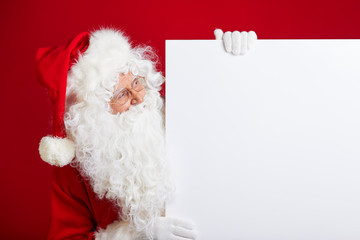 Santa Claus pointing in blank advertisement banner isolated on r