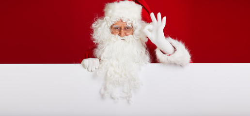 Santa Claus pointing in blank advertisement banner isolated on r