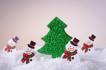 Christmas toys on snow snowman and tree