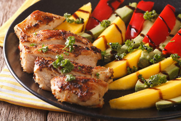 Salad with grilled chicken, mango, avocado and pepper close-up. horizontal
